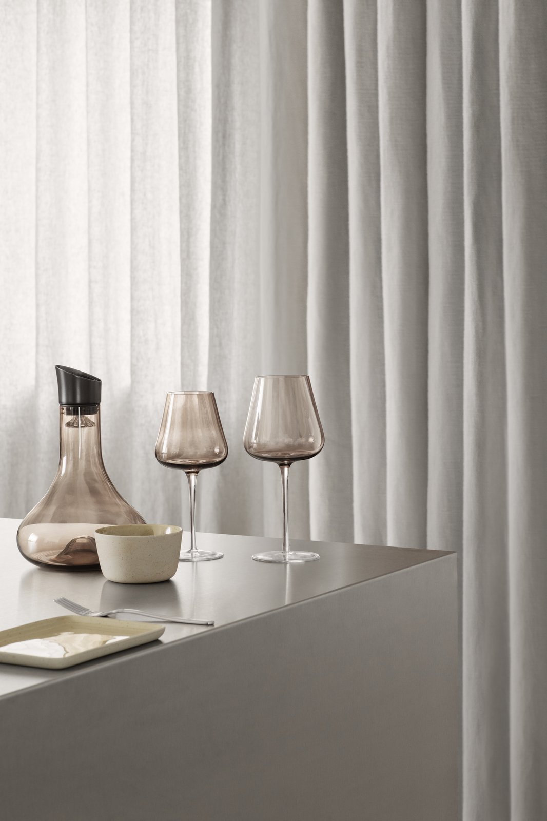 Elegantes Essens Arrangement mit rauchigen Glaskelchen und einer stilvollen Karaffe.
