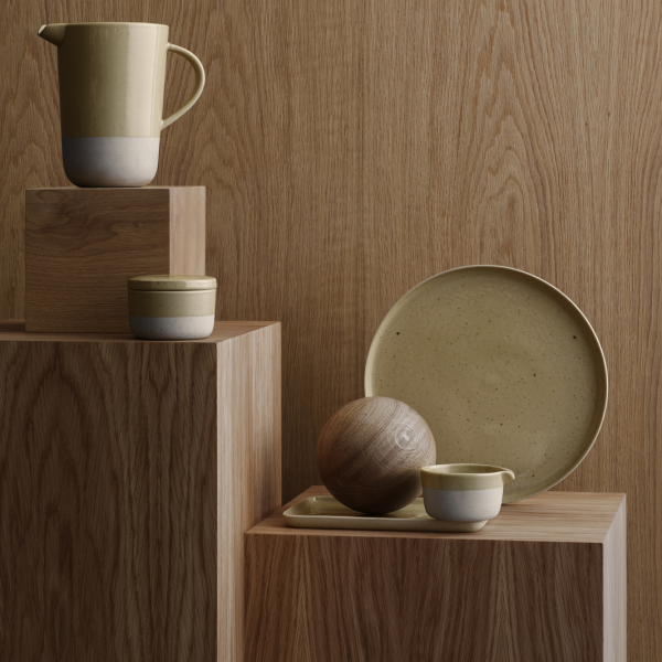 Minimalist ceramics and wooden objects displayed on wooden blocks for a stylish decor setting.