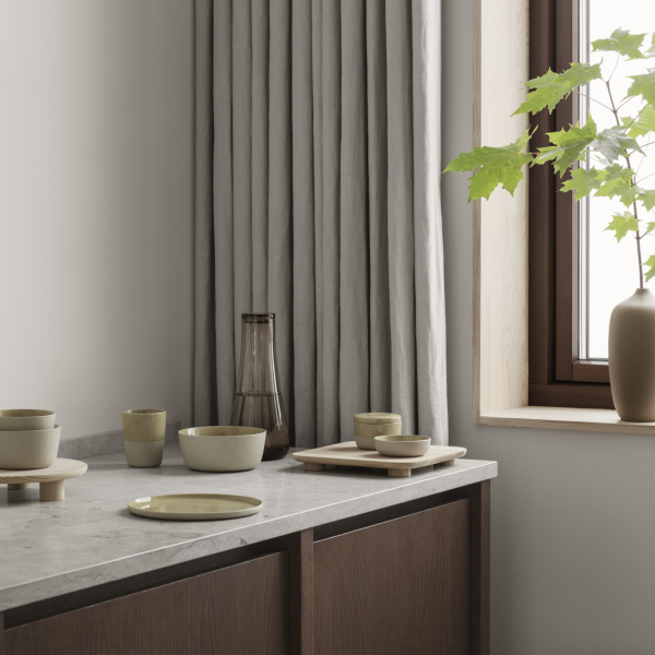 Minimalist dining setup with earthenware dishes and natural light from a window.