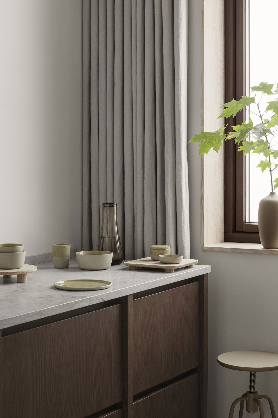Minimalist dining setup with earthenware dishes and natural light from a window.