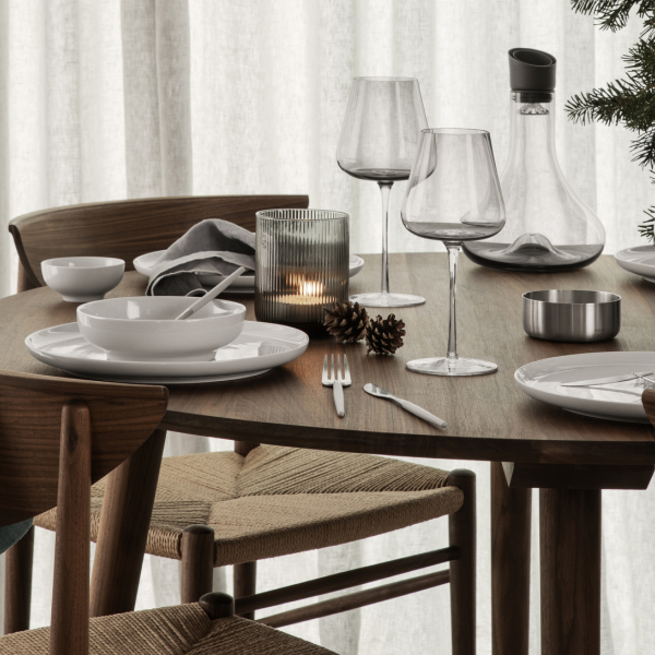 Elegantes Esstisch-Set für ein festliches Mahl mit modernem Geschirr und saisonaler Dekoration.