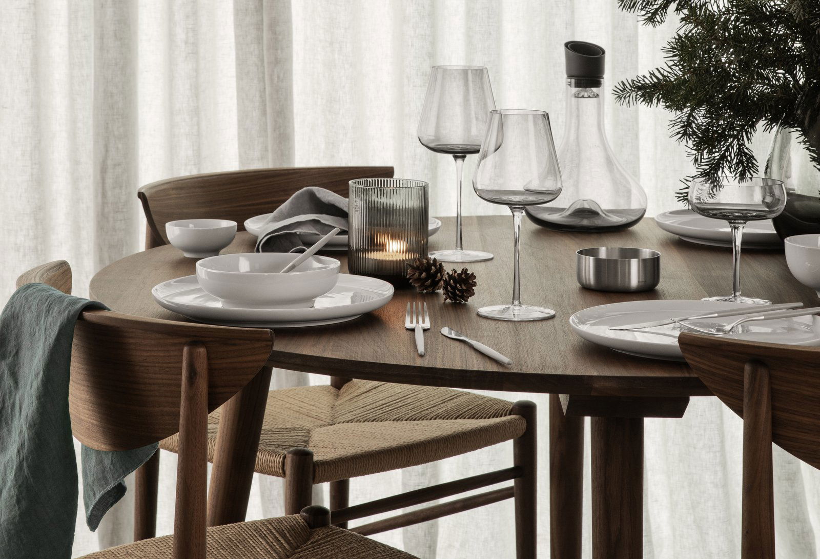 Elegantes Esstisch-Set für ein festliches Mahl mit modernem Geschirr und saisonaler Dekoration.