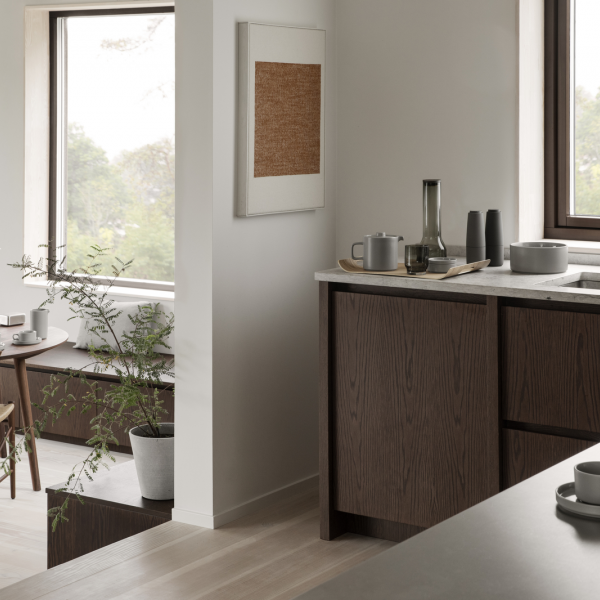 Modern kitchen with dark wood cabinetry and stylish decor in a bright, serene space.