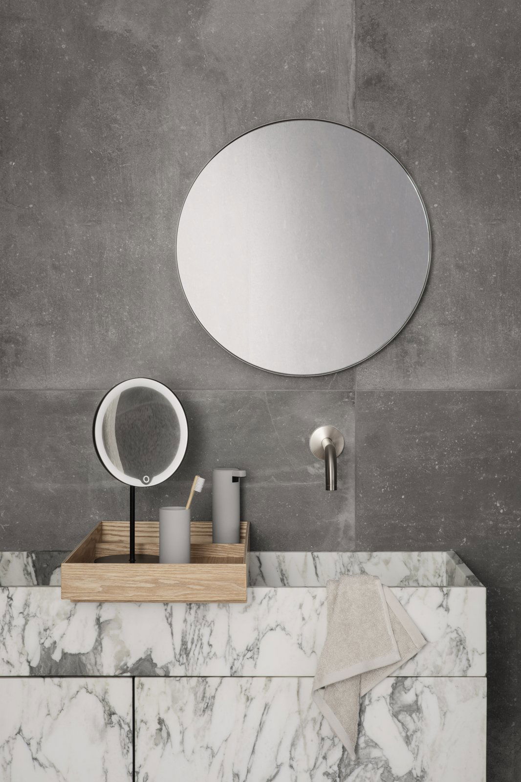 Modernes Badezimmer mit minimalistischer Dekoration, ausgestattet mit einem runden Spiegel und einer Marmorarbeitsplatte.