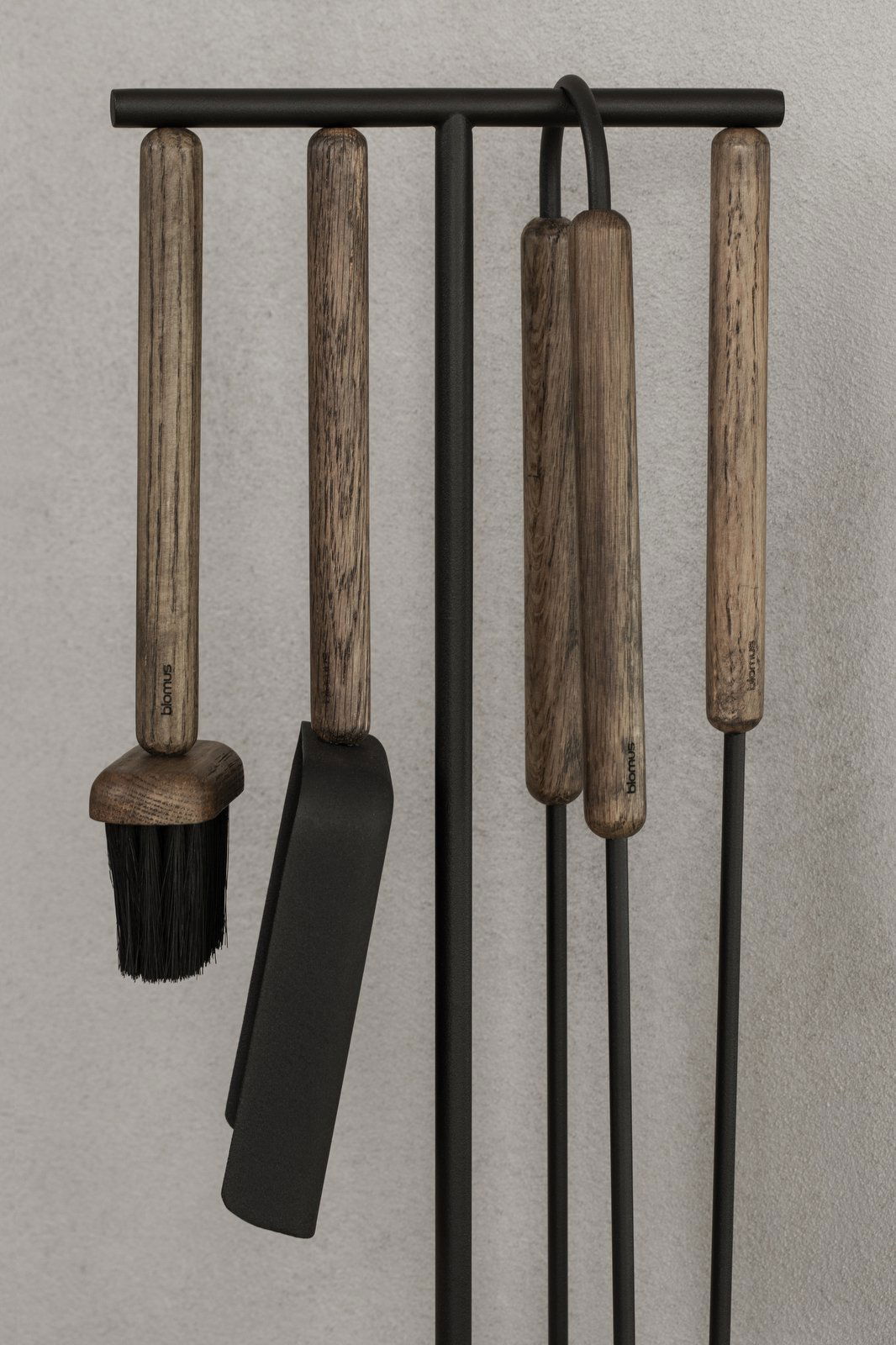 Stylish kitchen utensils with wooden handles displayed against a textured wall.