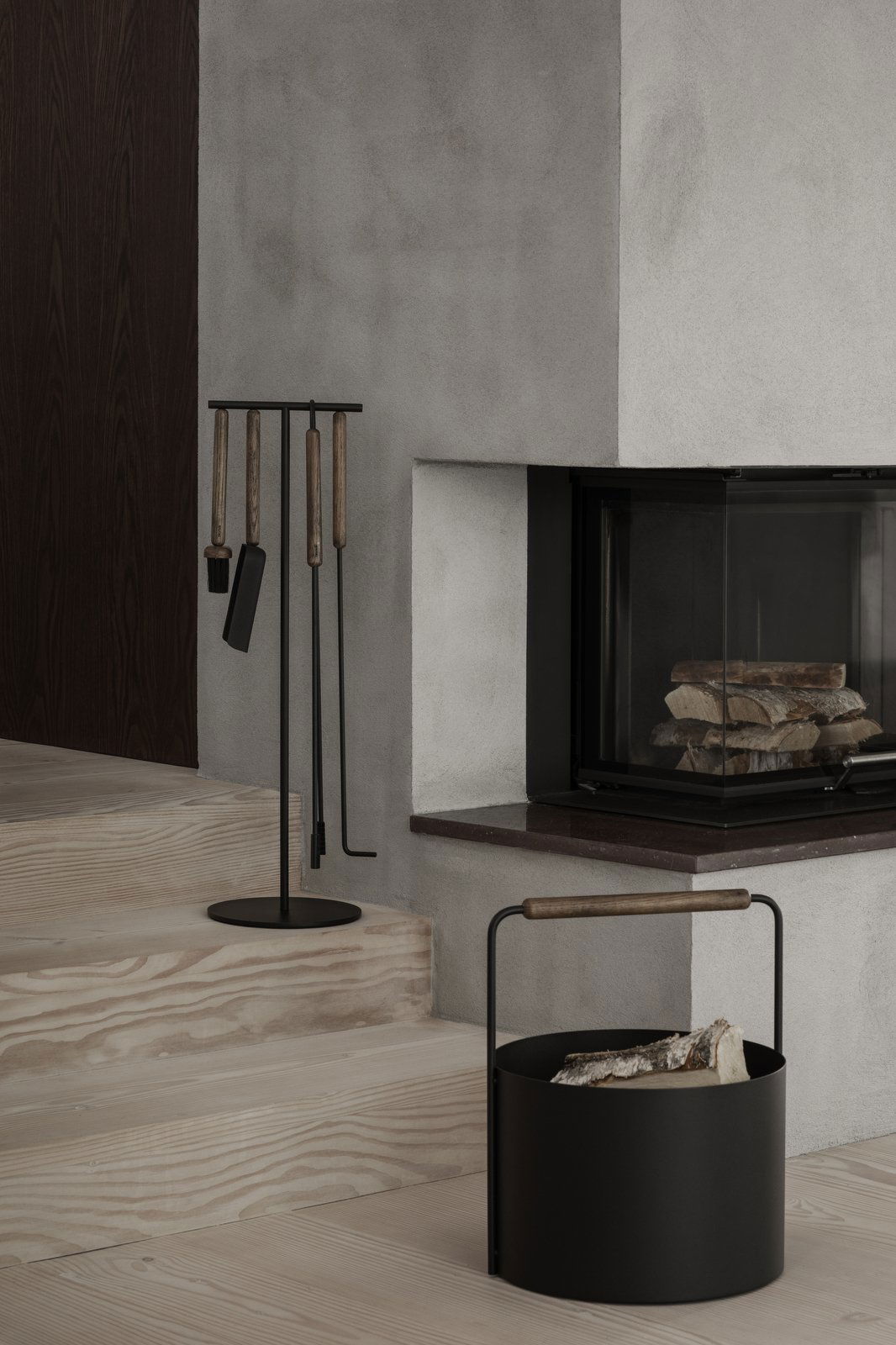 Modern fireplace tools elegantly displayed next to a minimalist fireplace in a cozy living space.