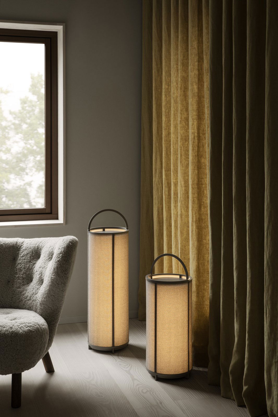 Moderner Wohnraum mit stilvollen Stehlampen und eleganten Vorhängen in der Nähe eines Fensters.