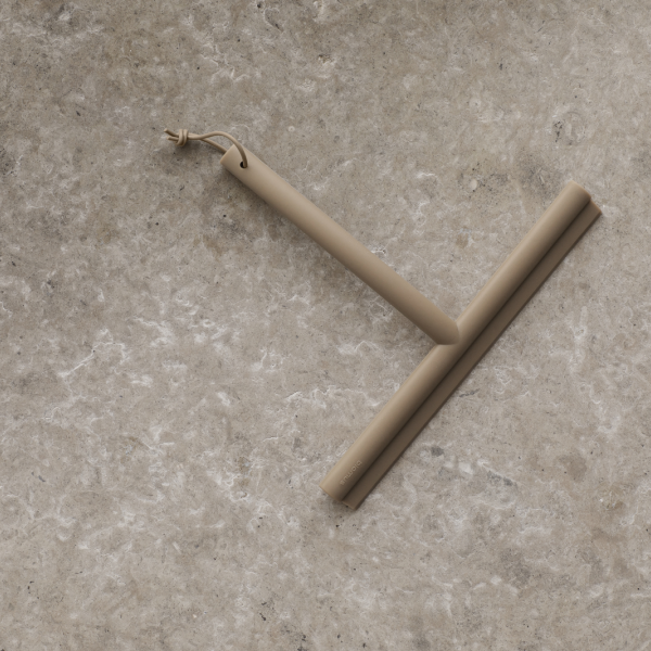 Minimalist beiger Abzieher auf einer strukturierten Steinoberfläche zum Reinigen und für die Wohnkultur.