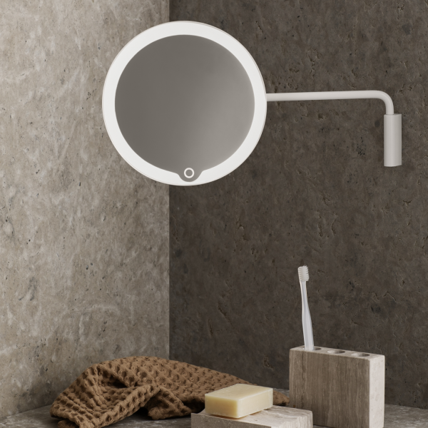 Modern wall-mounted mirror with LED lighting in a stylish bathroom setting.