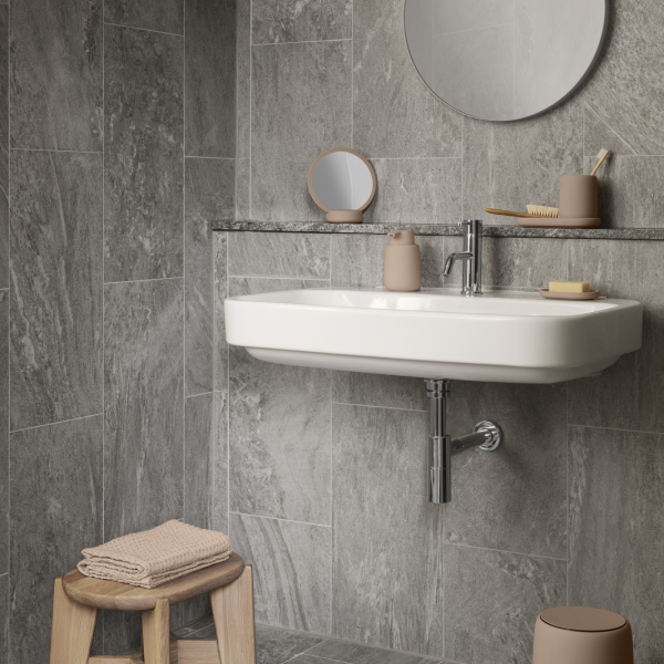 Modernes Badezimmer mit einem eleganten Waschbecken, grauen Fliesenwänden und minimalistischem Dekor.