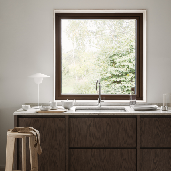 Moderne Küche mit einem eleganten Waschbecken und großem Fenster mit Blick auf das Grün.