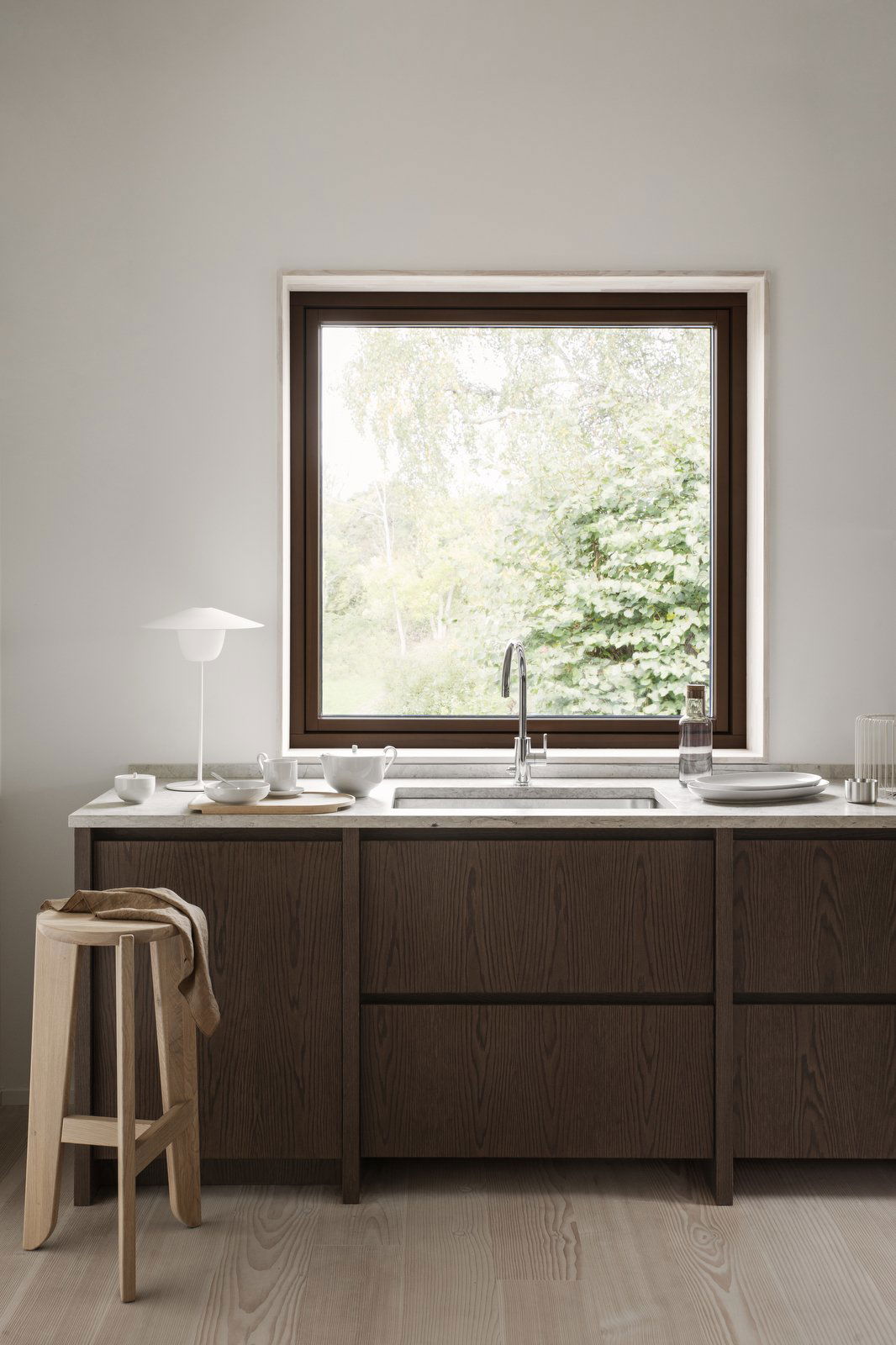 Moderne Küche mit einem eleganten Waschbecken und großem Fenster mit Blick auf das Grün.