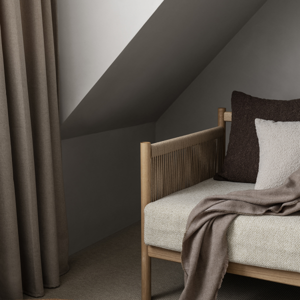 Gemütliche Ecke mit einem minimalistischen Bett, neutralen Tönen und sanften Texturen in einem modernen Interieur.
