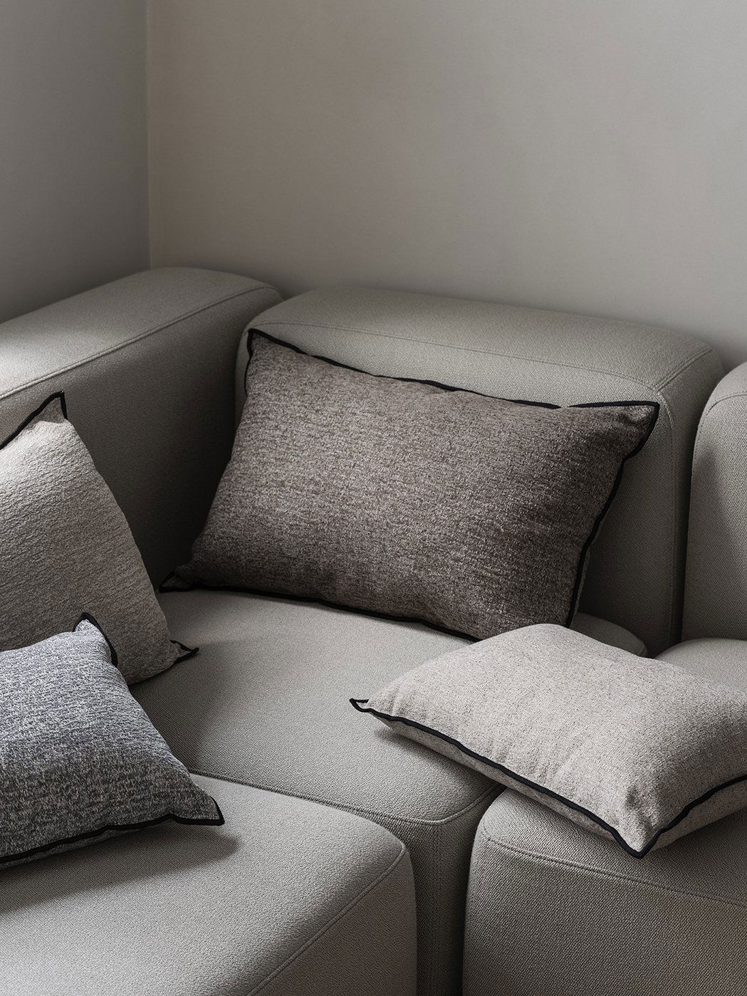 Elegante graue Kissen auf einem modernen Sofa, die zeitgemäße Wohnkultur aufwerten.