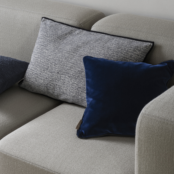 Modern sofa with stylish gray and navy throw pillows for a cozy living room aesthetic.