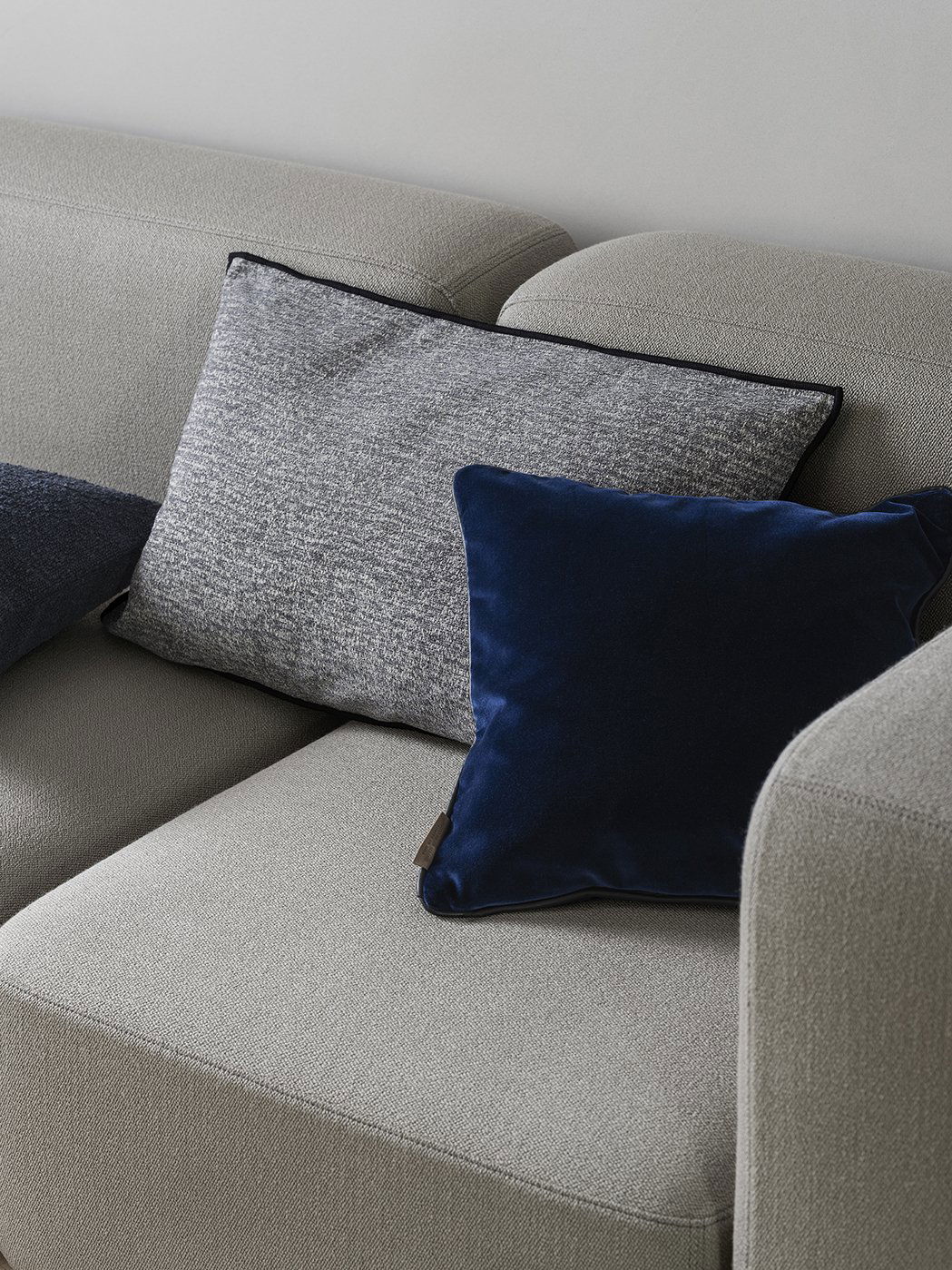 Modern sofa with stylish gray and navy throw pillows for a cozy living room aesthetic.