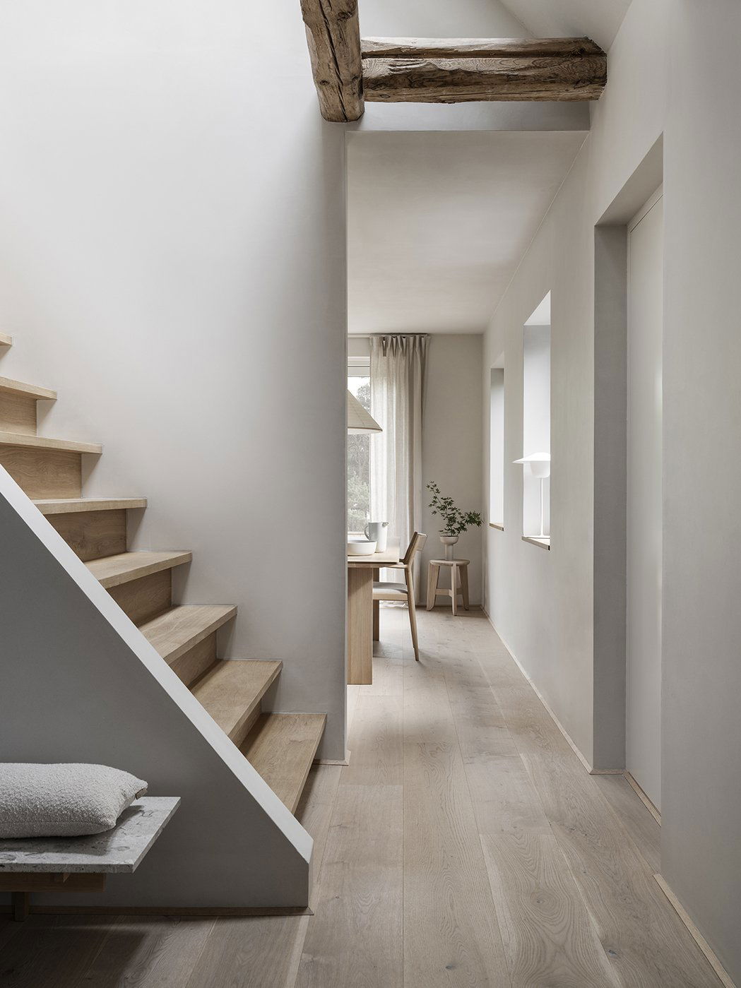 Helle moderne Flur mit Holztreppe und minimalistischer Dekoration.