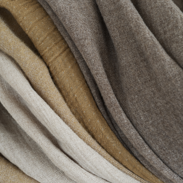 Textured fabric layers in neutral tones of beige, brown, and cream for interior design.