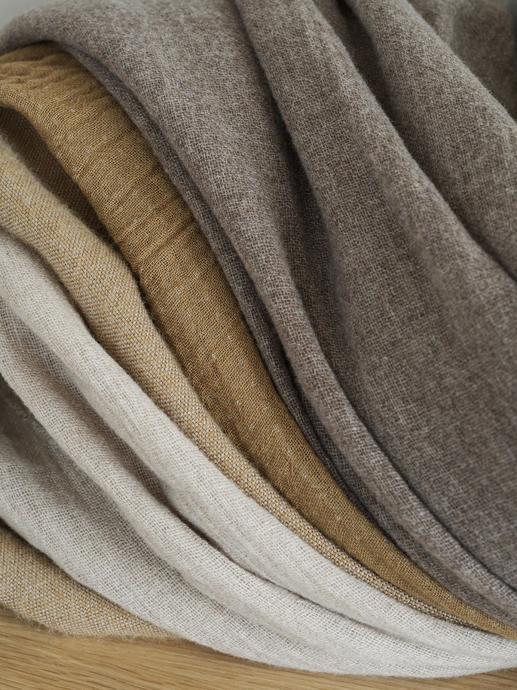 Textured fabric layers in neutral tones of beige, brown, and cream for interior design.