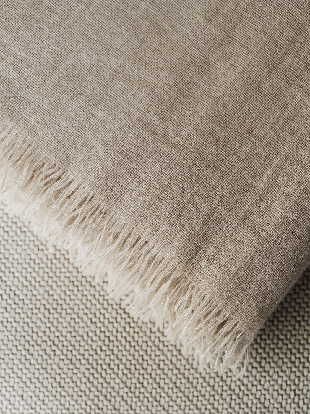 Natural linen fabric with frayed edges, showcasing a soft, textured surface.