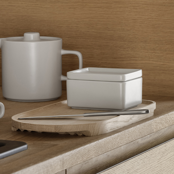 Moderne Küchenarbeitsplatte mit minimalistischem Geschirr und einem Holzservierteller.