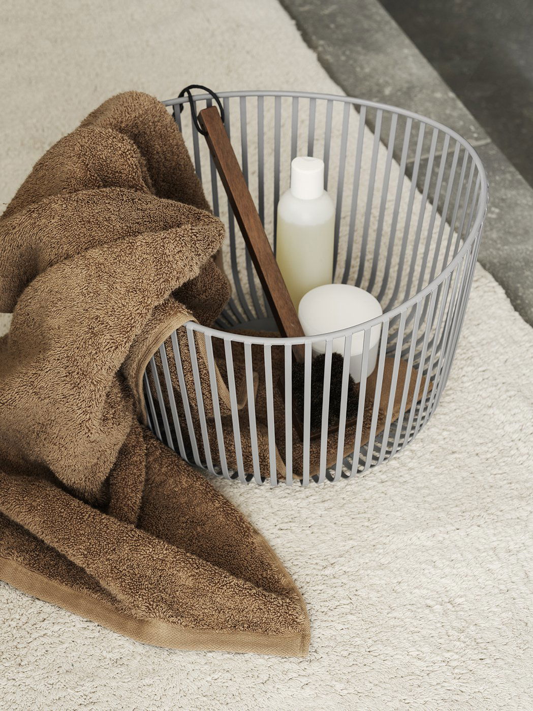 Neutrale Badezimmerdekoration mit Handtüchern, einem Korb und Toilettenartikeln auf einem weichen Teppich.