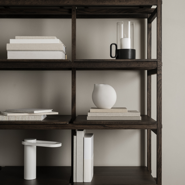 Moderne Bücherregalgestaltung mit Kerzen, Büchern und minimalistischen Dekorationselementen.