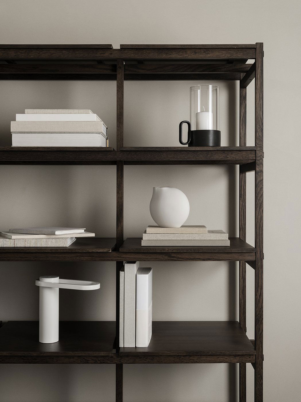 Moderne Bücherregalgestaltung mit Kerzen, Büchern und minimalistischen Dekorationselementen.