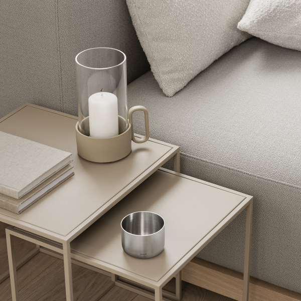 Moderne Wohnzimmerdekoration mit einem minimalistischen Couchtisch, Kerzen und Kissen.
