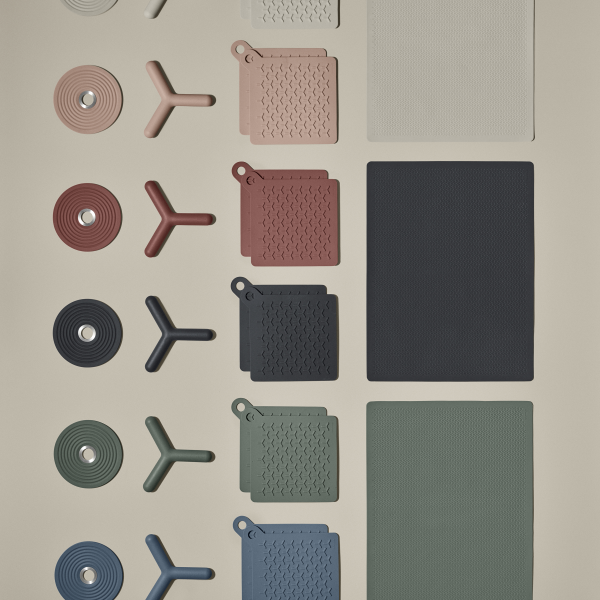 Collection of textured kitchenware and silicone mats in various colors on a neutral background.
