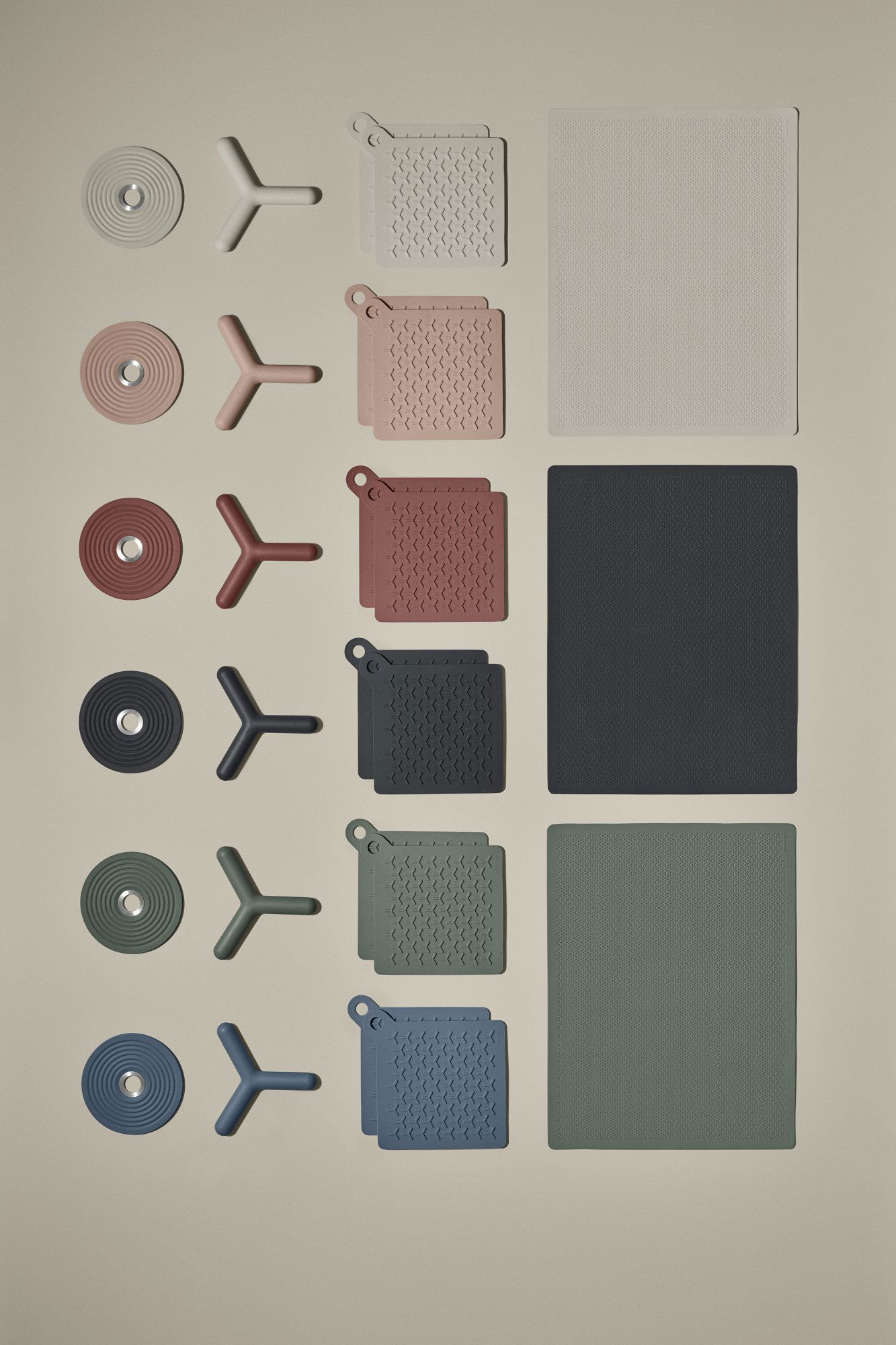 Collection of textured kitchenware and silicone mats in various colors on a neutral background.