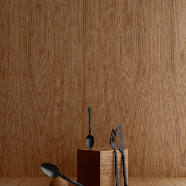 Black cutlery displayed on a wooden surface, highlighting modern tableware design.