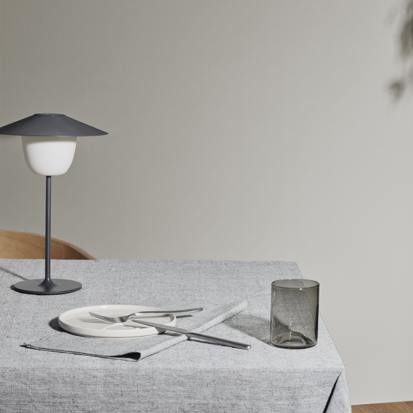 Modernes Esstisch-Setup mit minimalistischer Dekoration, featuring elegantes Geschirr und eine stilvolle Lampe.