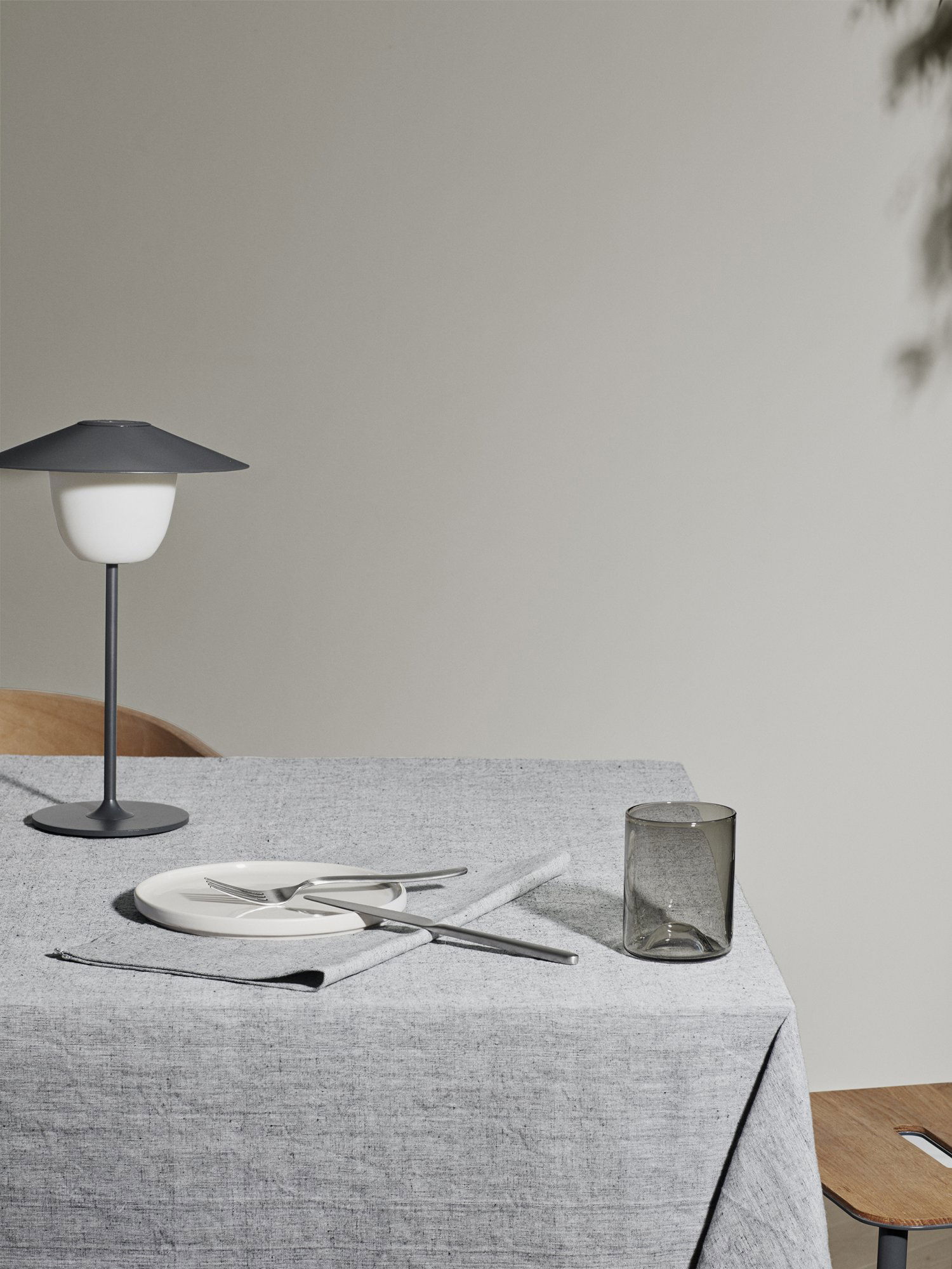 Modernes Esstisch-Setup mit minimalistischer Dekoration, featuring elegantes Geschirr und eine stilvolle Lampe.
