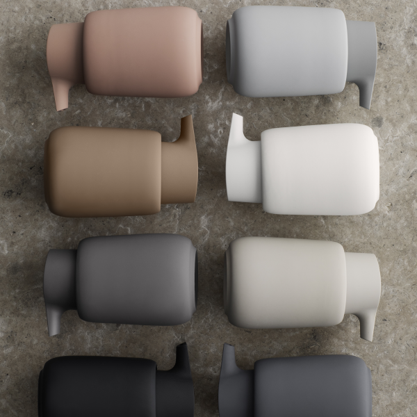 Stilvolle minimalistische Flaschen in neutralen Farben, die auf einer strukturierten Oberfläche angeordnet sind.