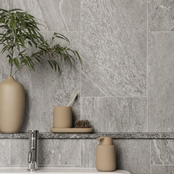 Stylish bathroom decor featuring gray stone walls and minimalist ceramic vases.
