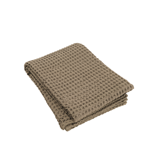 Cozy beige knitted blanket folded on a white background for home decor.