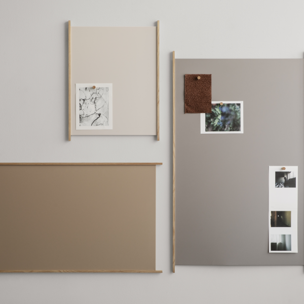 Decorative wall display featuring framed art and photos on neutral-colored backgrounds.
