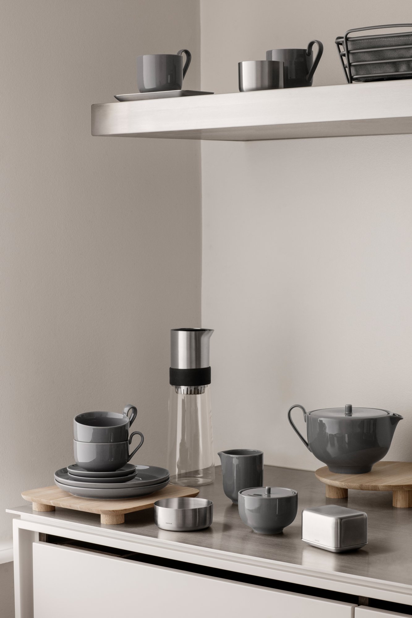 Moderne Kücheneinheit mit stilvollem grauem Geschirr und einer eleganten Kaffeekaraffe.