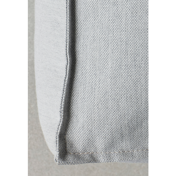 Close-up of a textured gray cushion against a neutral background.