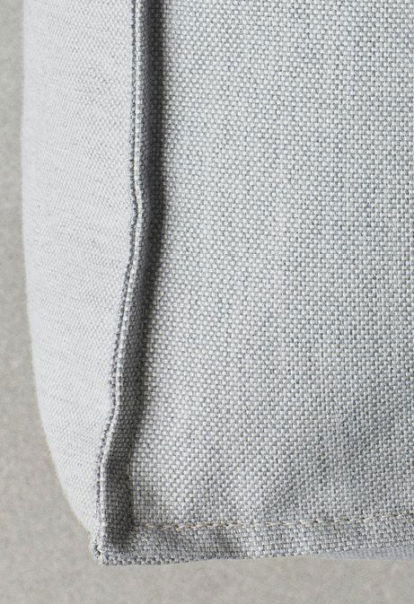 Nahaufnahme eines strukturierten grauen Stoffes, der ein modernes Kissen-Design zeigt.