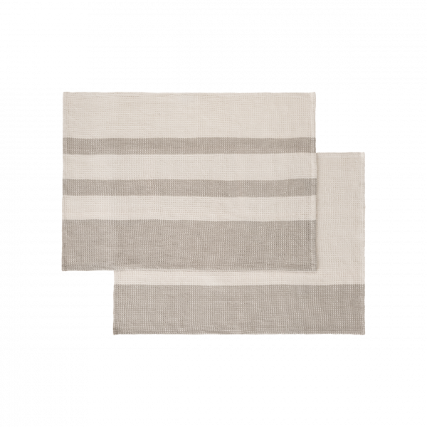 Striped woven placemats in neutral tones for stylish dining table decor.
