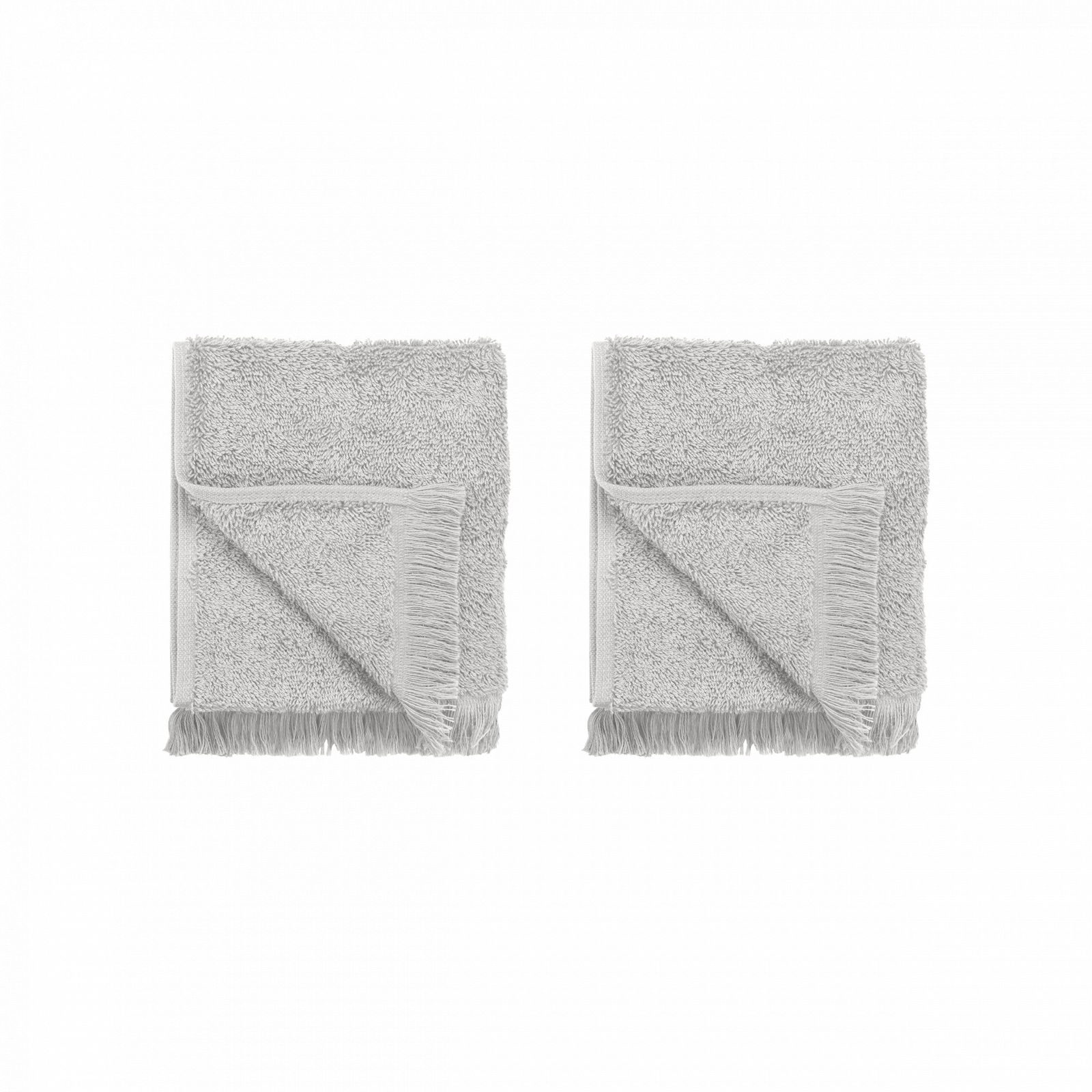 Soft gray towels folded neatly, featuring fringe edges on a black background.