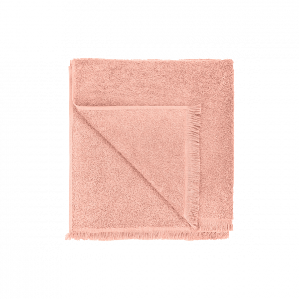 Soft pink towel folded neatly with a textured finish and fringed edges.