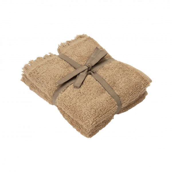 Soft, beige towel neatly tied with a ribbon on a black background.
