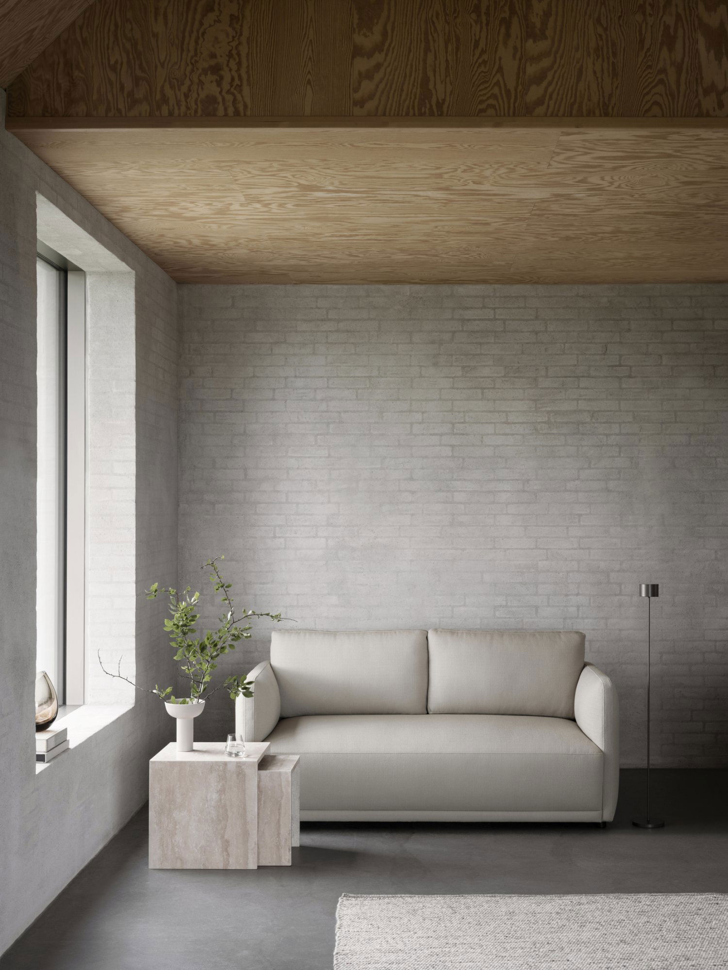 Modern living room featuring a minimalist sofa, natural light, and stylish decor elements.