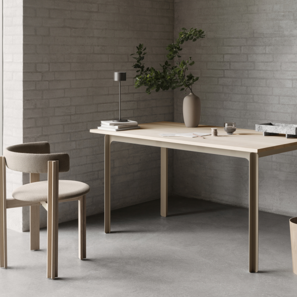 Scandi-style minimalistic workspace with a light wood table and simple decor.