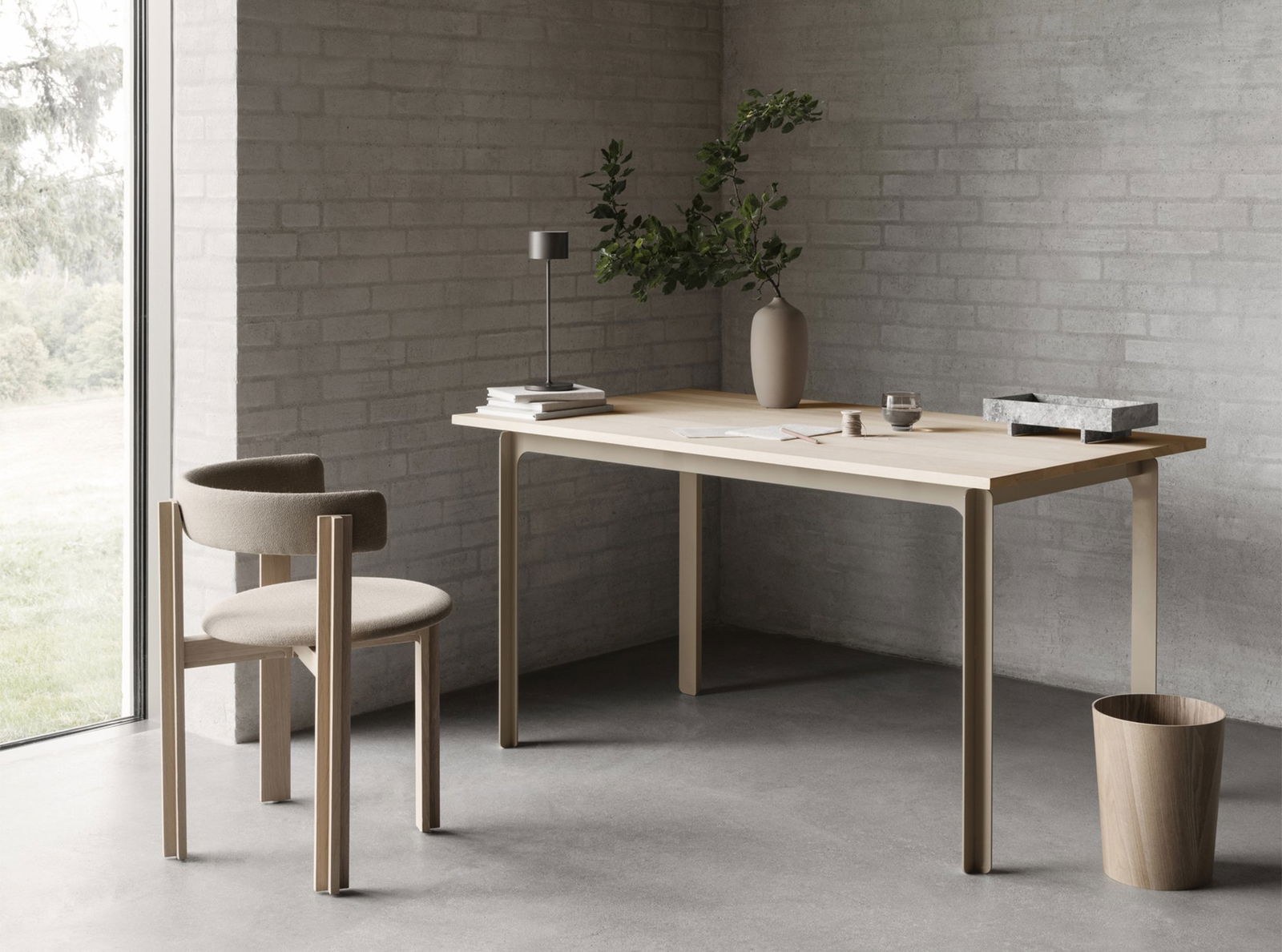 Scandi-style minimalistic workspace with a light wood table and simple decor.