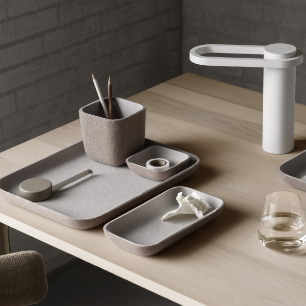 Minimalist desk setup featuring felt trays, a pencil holder, and a stylish lamp.