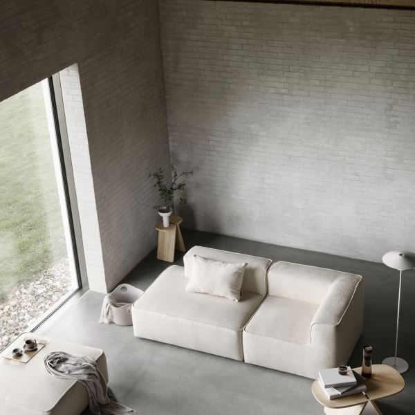 Modern living room featuring a minimalist beige sofa and natural light from large windows.